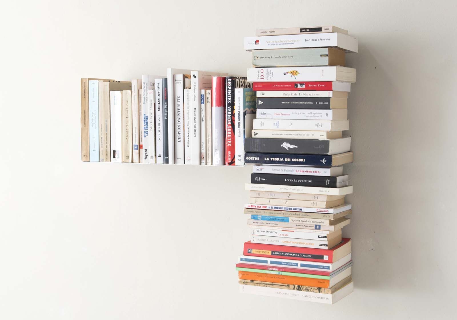 bibliothèque murale gauche installée dans un salon moderne avec des livres empilés